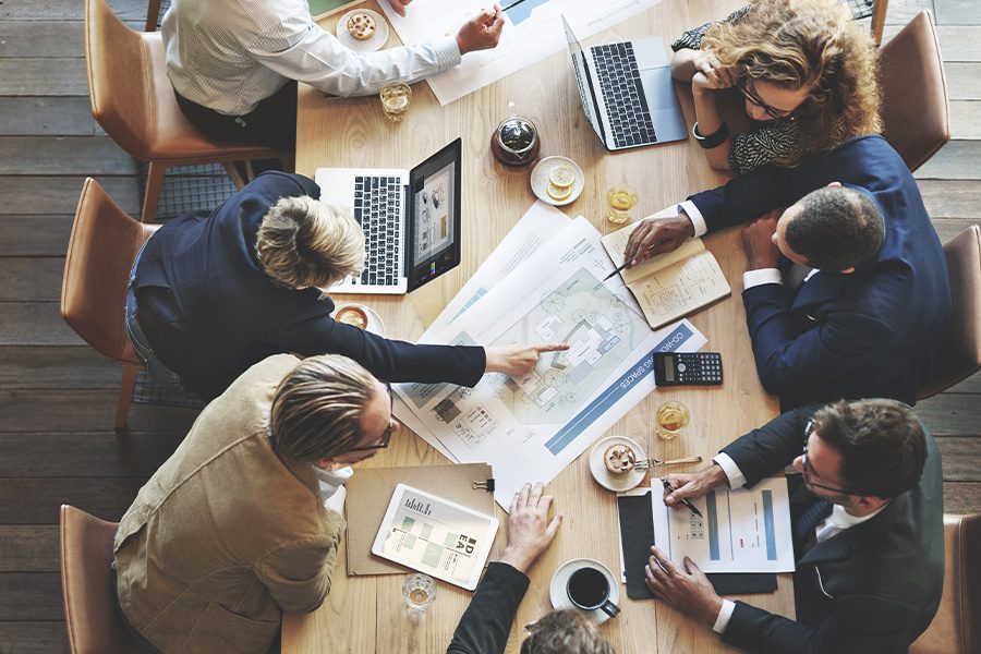 About Our Agency - Overhead View of Business People Meeting in a Conference Room to Discuss Insurance Solutions