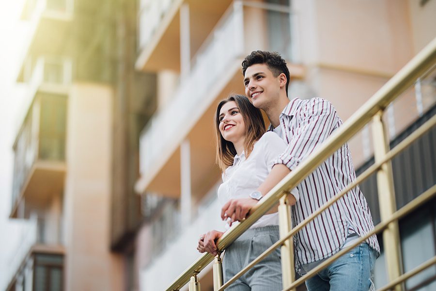 Habitational Risks - Happy Couple Relaxing and Having Fun on the Balcony of Their New Apartment